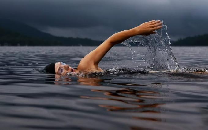 Человек купается в озере.